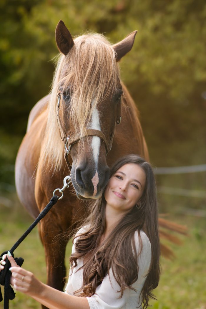 Portrait d’une cavalière et de son cheval alezan en fin de journée